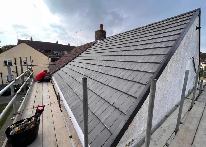 Grey tiled gable roof just completed, scaffolding still in place