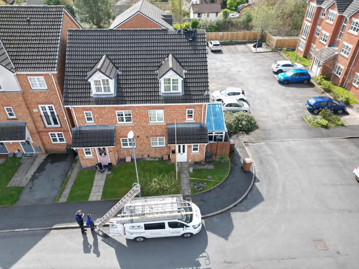 Aerial view of a new-build street, with the ASAP Roofing van and ladders on the road below